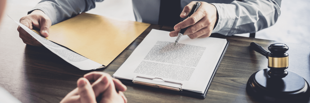 Consultation between a businessman and male lawyer at desk with legal papers. Law and Legal services concept.