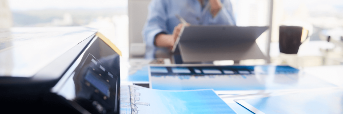  Girl with computer laptop for photo editing. Close-up of printer printing picture on photographic paper, small business office equipment or printer