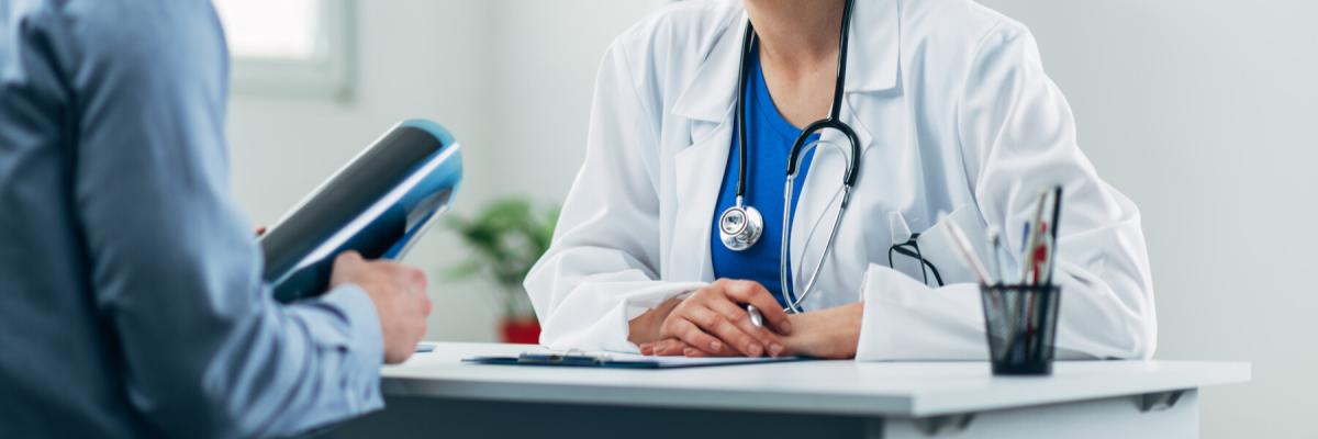 Healthcare worker talking to a patient at the receptionist desk